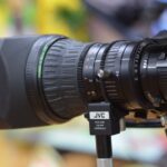 Un tecnico che analizza una telecamera industriale per la visione artificiale in un ambiente di produzione.